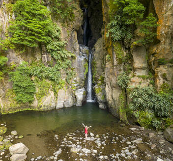 Aerial view of a woman bathing at Salto do Cabritol waterfall,, Azores, Portugal. - AAEF15158