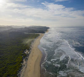 Luftaufnahme des Strandes und der Küstenlinie mit Wellen bei Sonnenuntergang und Wald, Knysna NU, Westkap, Südafrika. - AAEF15194