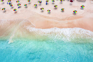 Multi colored umbrellas on tropical beach washed by waves of Caribbean Sea, aerial view, Antigua, West Indies, Caribbean, Central America - RHPLF22684