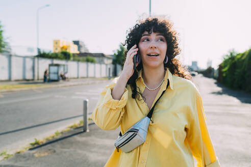 Young woman talking on mobile phone on street - MEUF07454