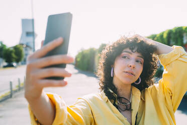 Frau posiert und nimmt Selfie durch Smartphone - MEUF07456