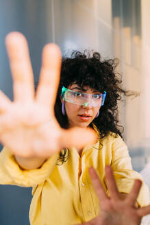 Junge Frau mit Cyberbrille macht Stop-Geste - MEUF07562