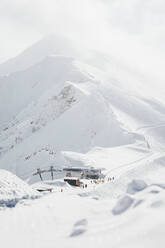 Blick auf die Seilbahnstation vor den schneebedeckten Bergen - OMIF01049