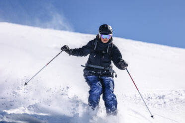 Frau beim Skifahren auf verschneiter Piste - OMIF01053