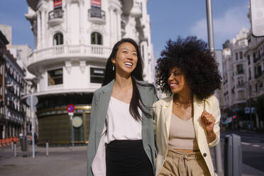 Happy multiracial friends strolling together in city - MMPF00201