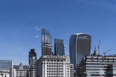 Skyscrapers under blue sky on sunny day in London, England - PNAF04291