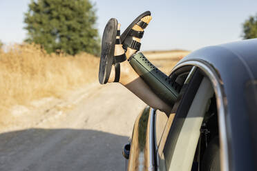 Mann mit Beinprothese entspannt sich an einem sonnigen Tag im Auto - JCCMF06960