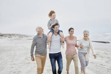 Happy couple spending quality time at the beach with son and grandparents - RORF03004