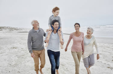 Happy couple spending quality time at the beach with son and grandparents - RORF03006