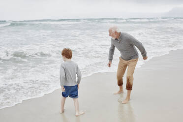 Grandfather playing with grandson at the sea - RORF03019