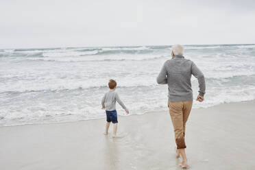 Grandfather playing with grandson at the sea - RORF03021