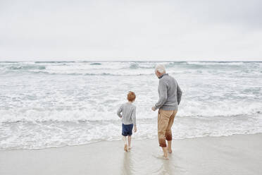 Grandfather playing with grandson at the sea - RORF03022