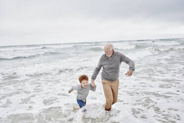Grandfather playing with grandson at the sea - RORF03023