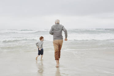 Grandfather playing with grandson at the sea - RORF03024