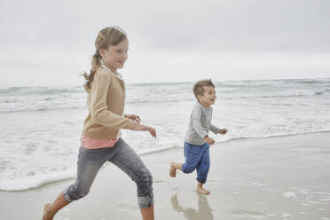 Bruder und Schwester haben Spaß beim Laufen am Strand - RORF03031