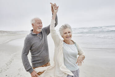 Happy senior couple dancing on the beach - RORF03040