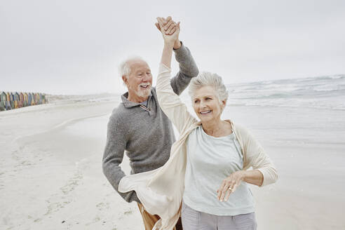 Glückliches älteres Paar tanzt am Strand - RORF03041
