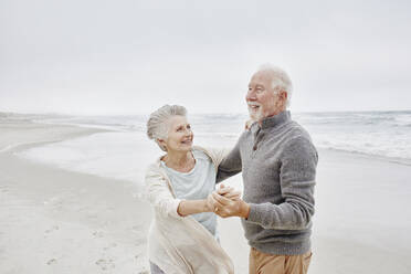 Glückliches älteres Paar tanzt am Strand - RORF03042