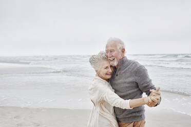 Glückliches älteres Paar tanzt am Strand - RORF03043