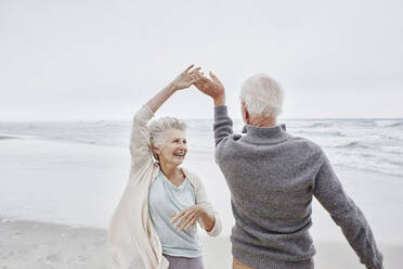 Happy senior couple dancing on the beach - RORF03044