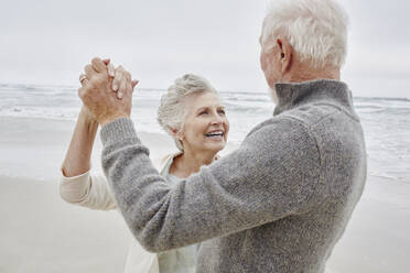 Glückliches älteres Paar tanzt am Strand - RORF03046