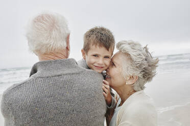 Happy grandparents spending quality time on the beach with grandson - RORF03052