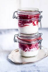 Two jars of homemade frozen yogurt with raspberry topping - SBDF04541