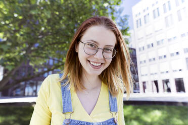 Glückliche junge Frau mit Brille - KMKF01876
