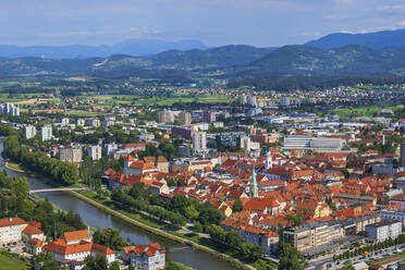 Slowenien, Savinja, Celje, Luftaufnahme der Altstadt am Flussufer im Sommer mit Hügeln im Hintergrund - ABOF00791