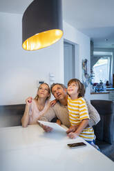 Familie steuert Deckenlampe mit Tablet-PC im Smart Home - DIGF18612