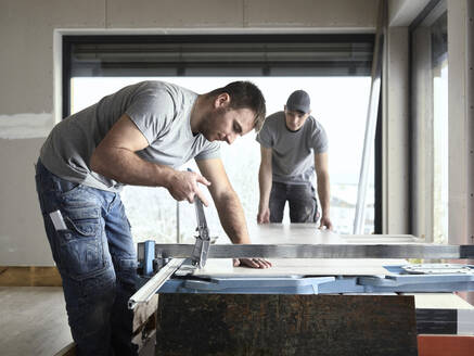 Tiler cutting tile with machine at construction site - CVF02107