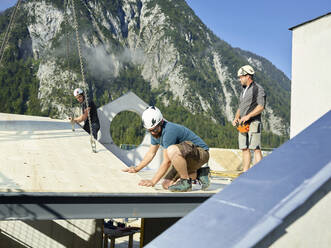 Carpenters installing roof at construction site - CVF02116