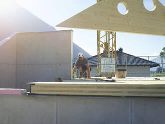 Craftsperson working on rooftop at construction site - CVF02121