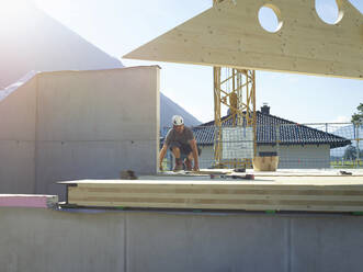 Handwerker bei Arbeiten auf dem Dach einer Baustelle - CVF02121