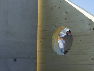 Zimmerer mit Bauplan auf der Baustelle - CVF02126