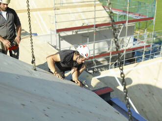 Zimmermann bei der Montage von Holzbrettern auf dem Dach einer Baustelle - CVF02128