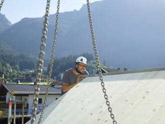 Zimmermann bei der Arbeit auf der Baustelle an einem sonnigen Tag - CVF02132