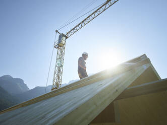 Zimmermann auf dem Dach einer Baustelle unter freiem Himmel - CVF02155