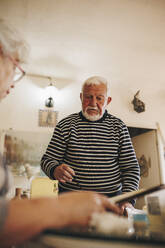 Älterer Mann im Gespräch mit Künstlerin zu Hause - MRRF02340