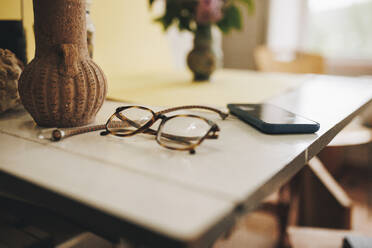 Brillen und Smartphones werden zu Hause auf dem Tisch aufbewahrt - MRRF02344