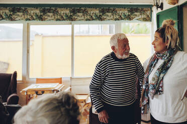 Älterer Mann und Frau stehen zu Hause - MRRF02346