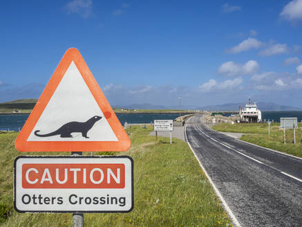 Vereinigtes Königreich, Schottland, Fischotter-Kreuzungsschild neben einer asphaltierten Straße auf den Äußeren Hebriden - HUSF00295