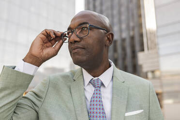 Mature businessman with eyeglasses at financial district - JCCMF07093