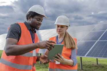 Engineer and co worker sharing tablet PC at solar station - OSF00636