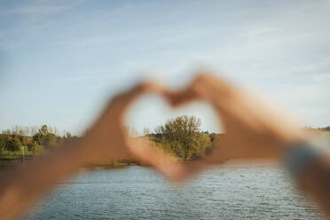 Tree seen from woman making heart shape - ACPF01448