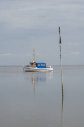 Germany, Schleswig-Holstein, Pellworm, Fishing boat at low tide - KEBF02382