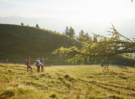 Wanderer, der auf Freunde zeigt, die auf einem Berg stehen, Mutters, Tirol, Österreich - CVF02166