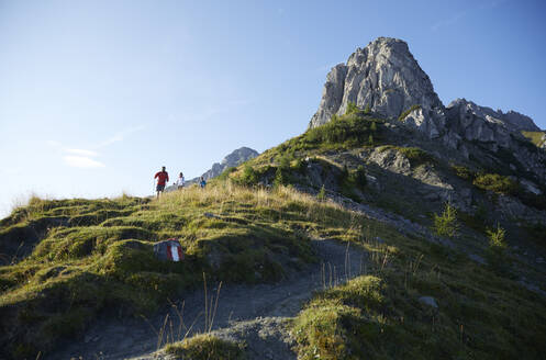 Wanderer beim Abstieg vom Berg an einem sonnigen Tag, Mutters, Tirol, Österreich - CVF02169