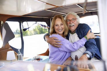 Glückliches älteres Paar umarmt sich im Boot - RHF02608
