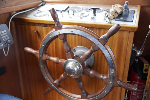 Hölzernes Ruder eines Motorbootes auf dem Armaturenbrett im Cockpit - RHF02620
